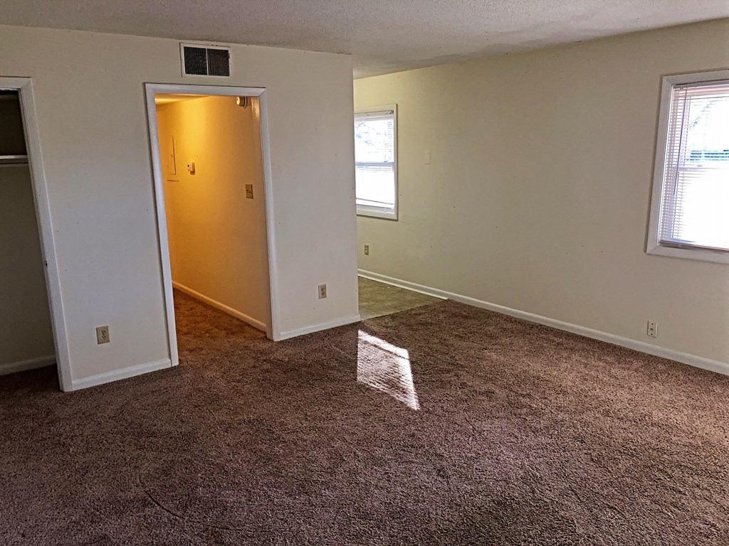 a room with a carpeted floor and a yellow door