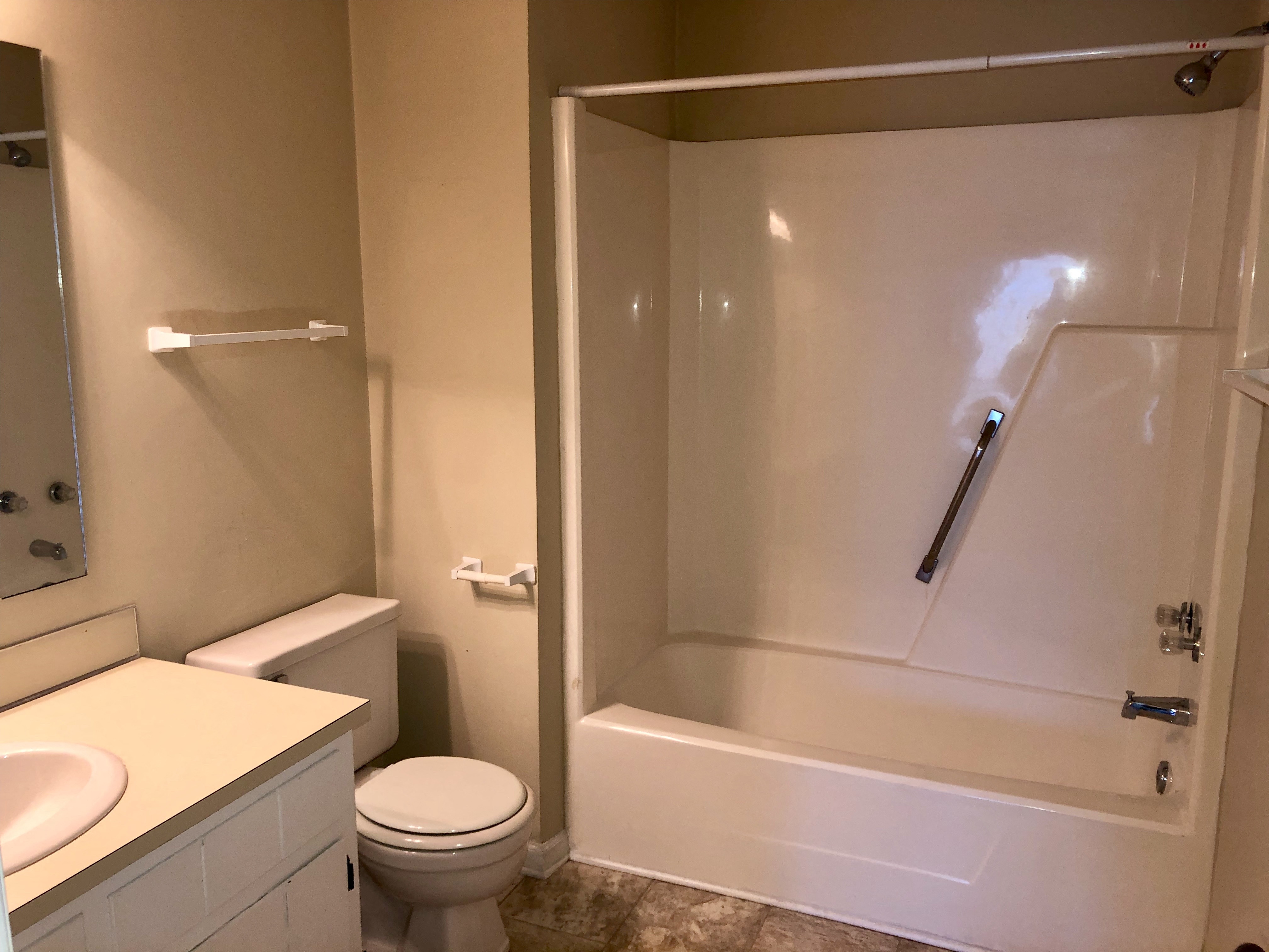 A white bathroom with a toilet, sink, and bathtub.