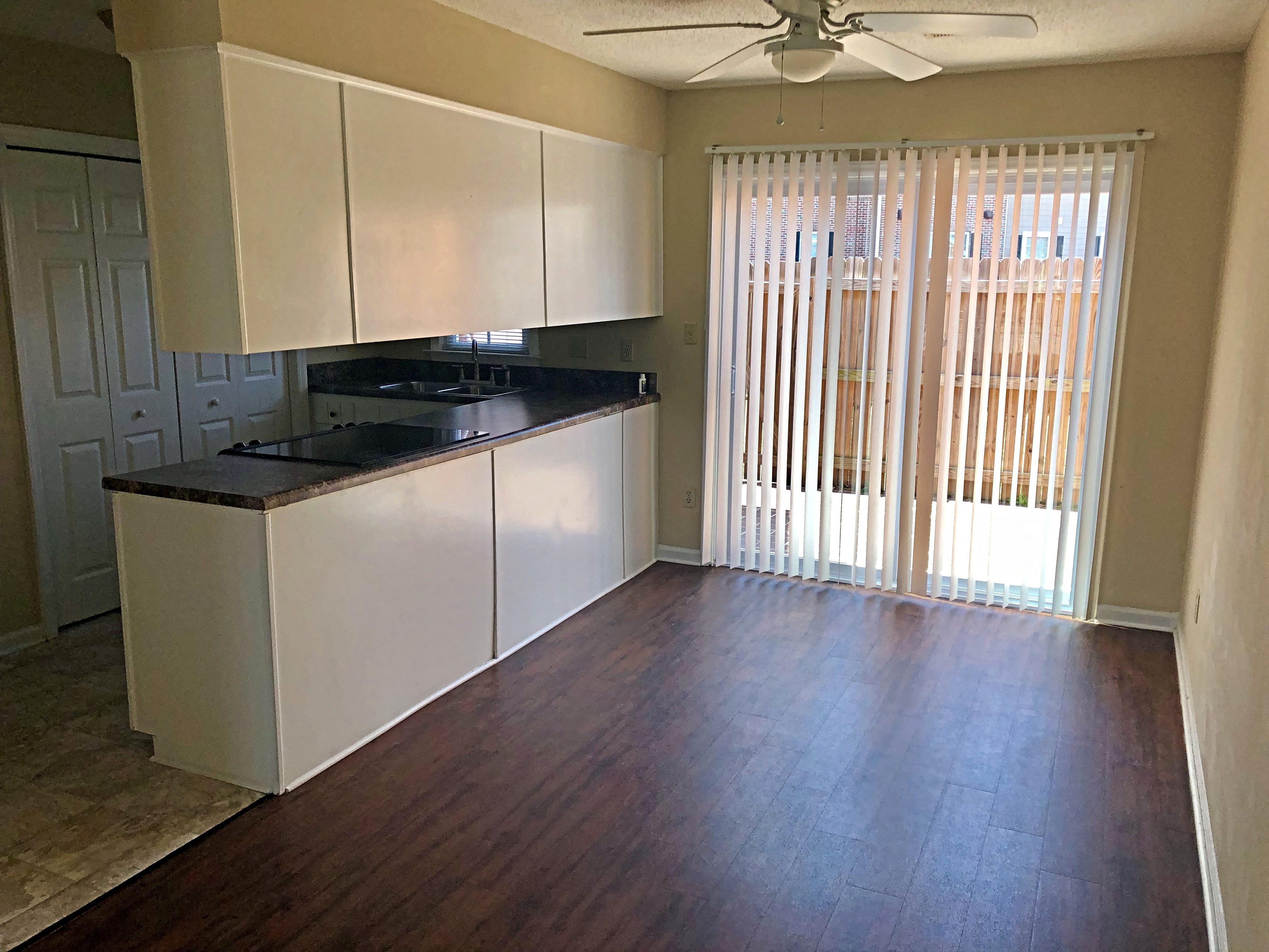 A kitchen with white cabinets and a black countertop.
