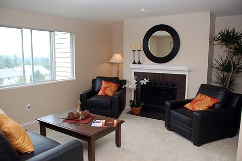 A living room with two black leather chairs and a fireplace.