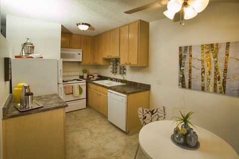 A kitchen with a table and chairs.