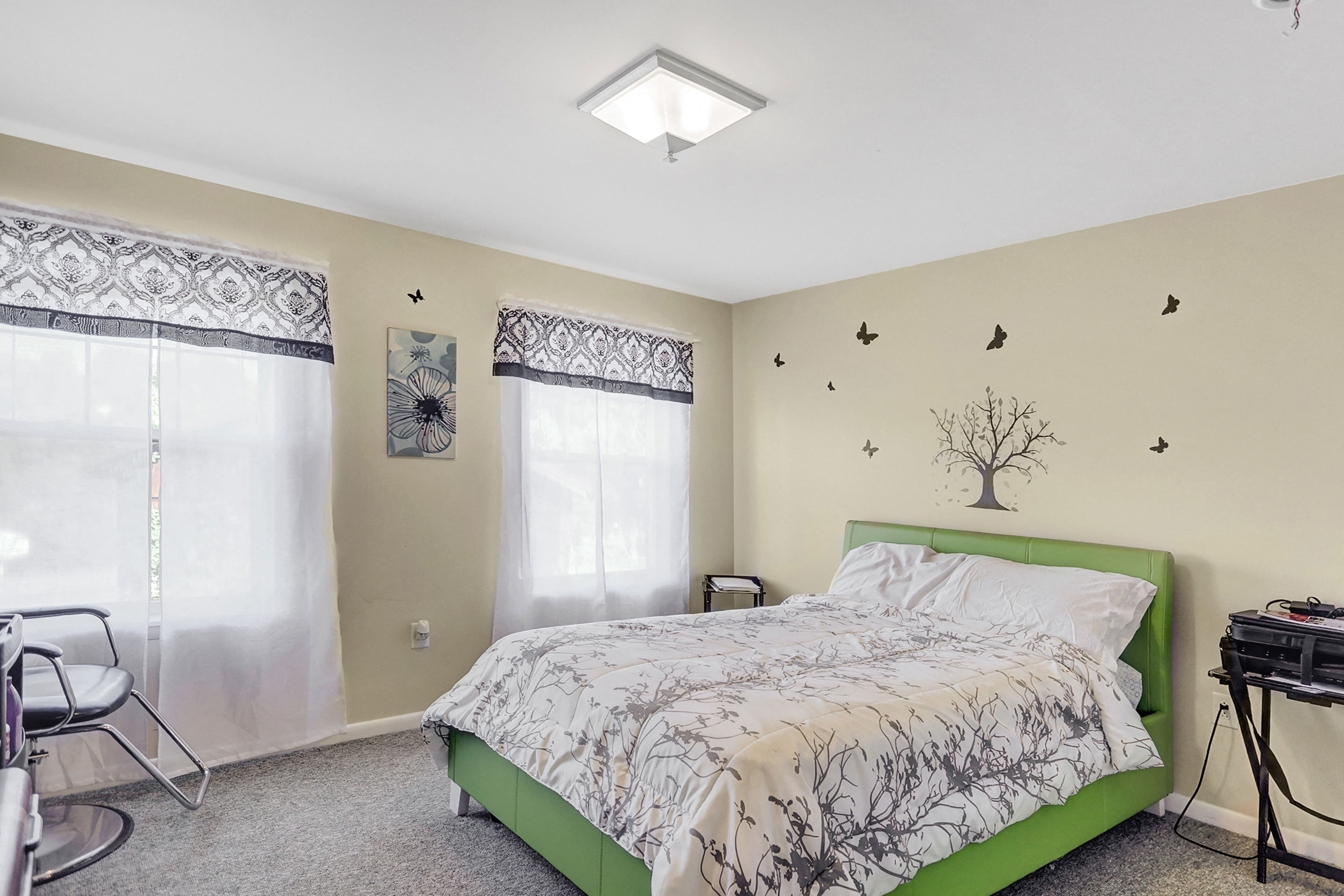 a bedroom with a bed and a tree on the wall