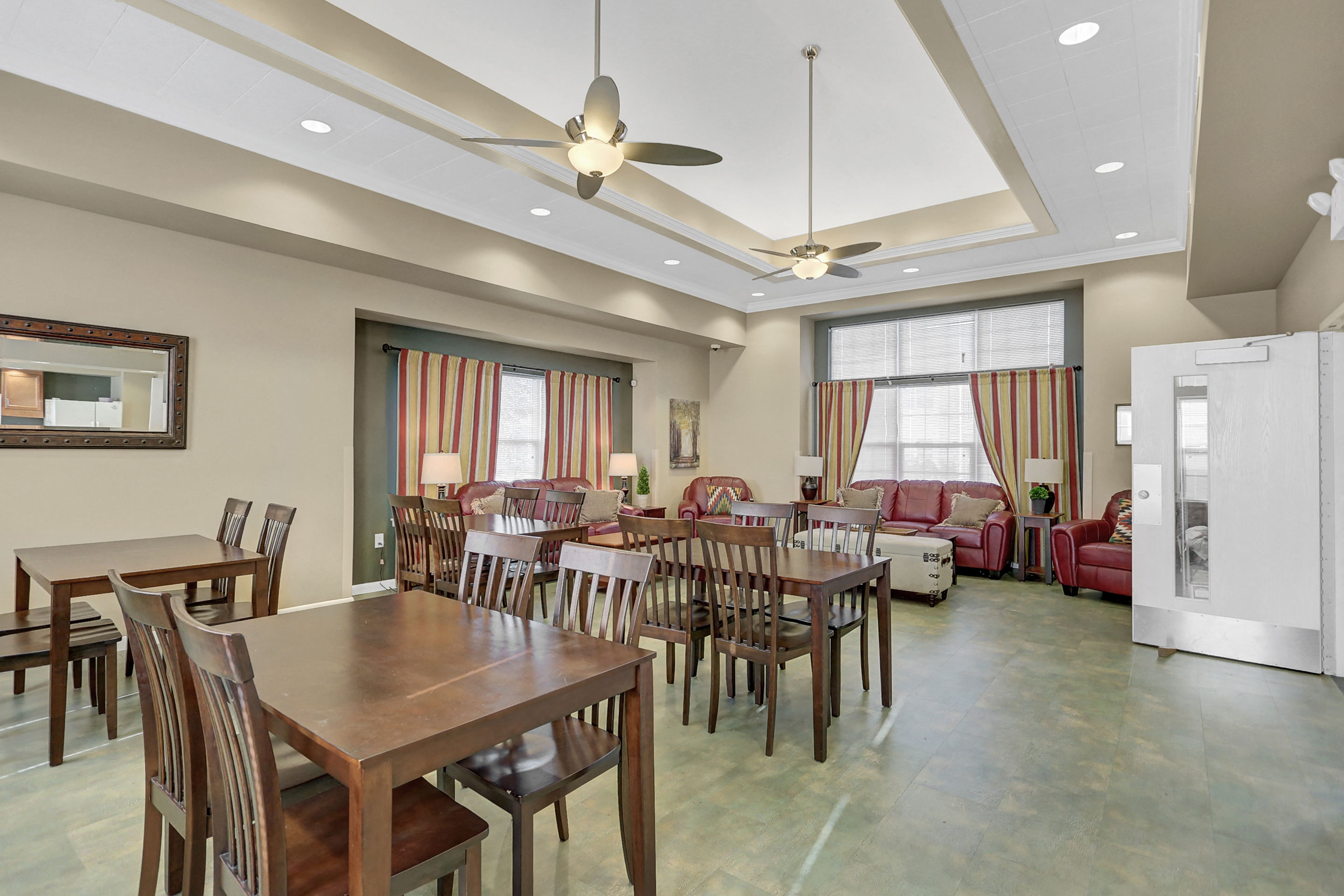 a dining room with tables and chairs and a living room with couches