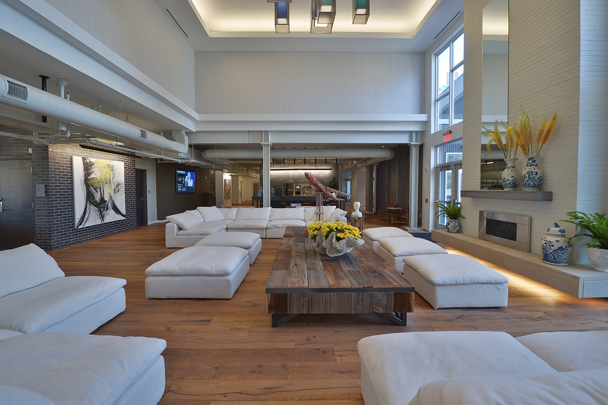 a large living room with white couches and a wooden table