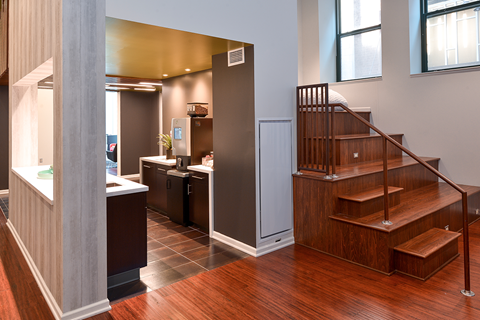 a home with a staircase and a kitchen with wood floors