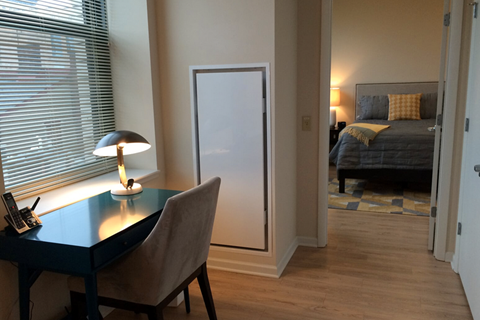 a home office with a desk and a bedroom with a bed