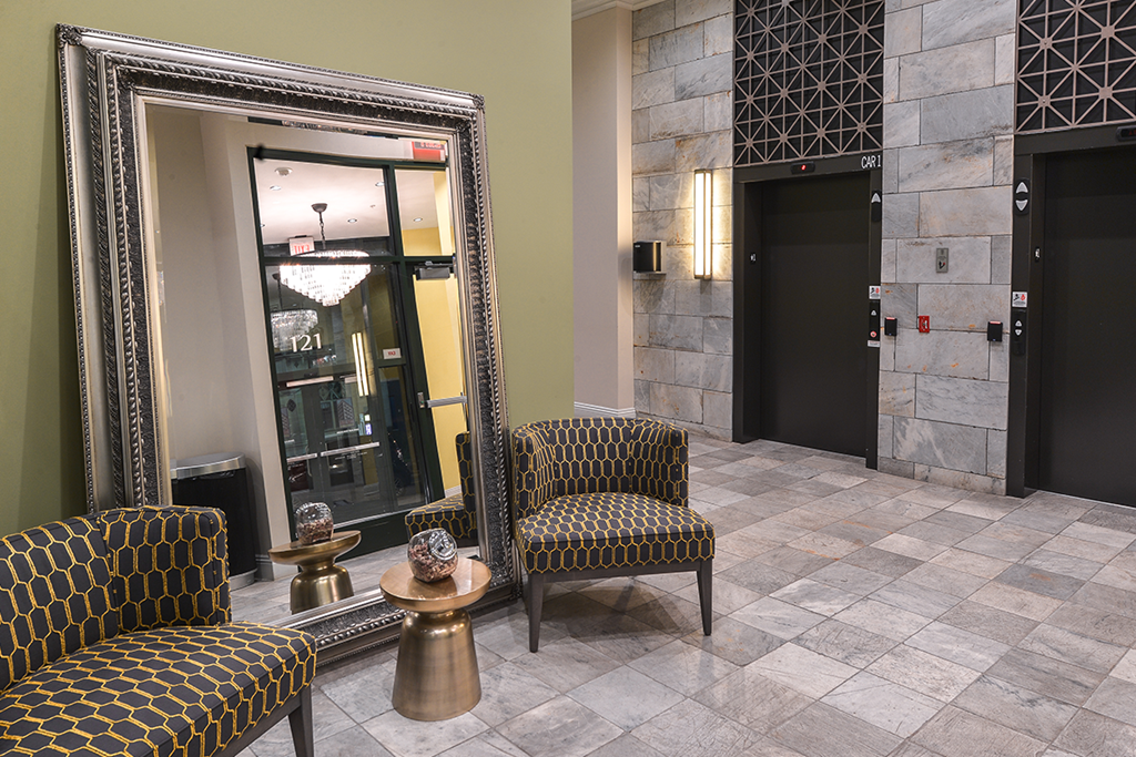 a lobby with chairs and a large mirror