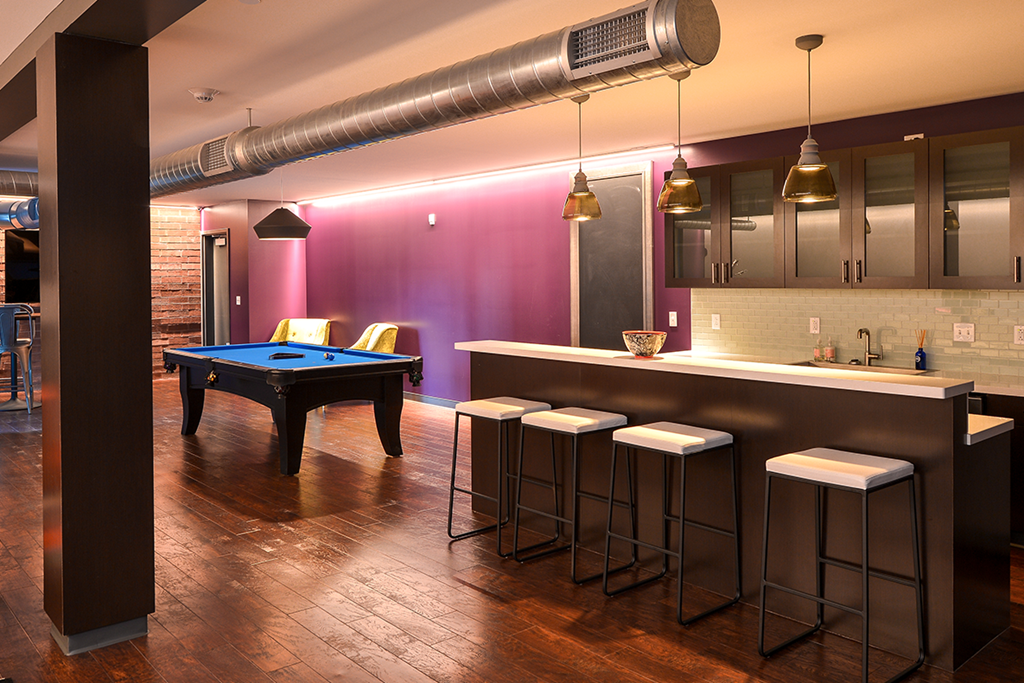 a game room with a pool table and bar