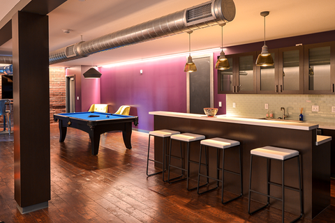 a game room with a pool table and bar