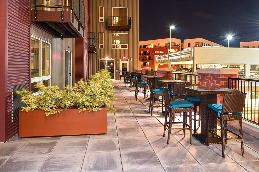 a patio with tables and chairs at night