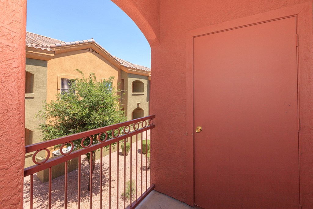 a red door with a balcony in front of a house