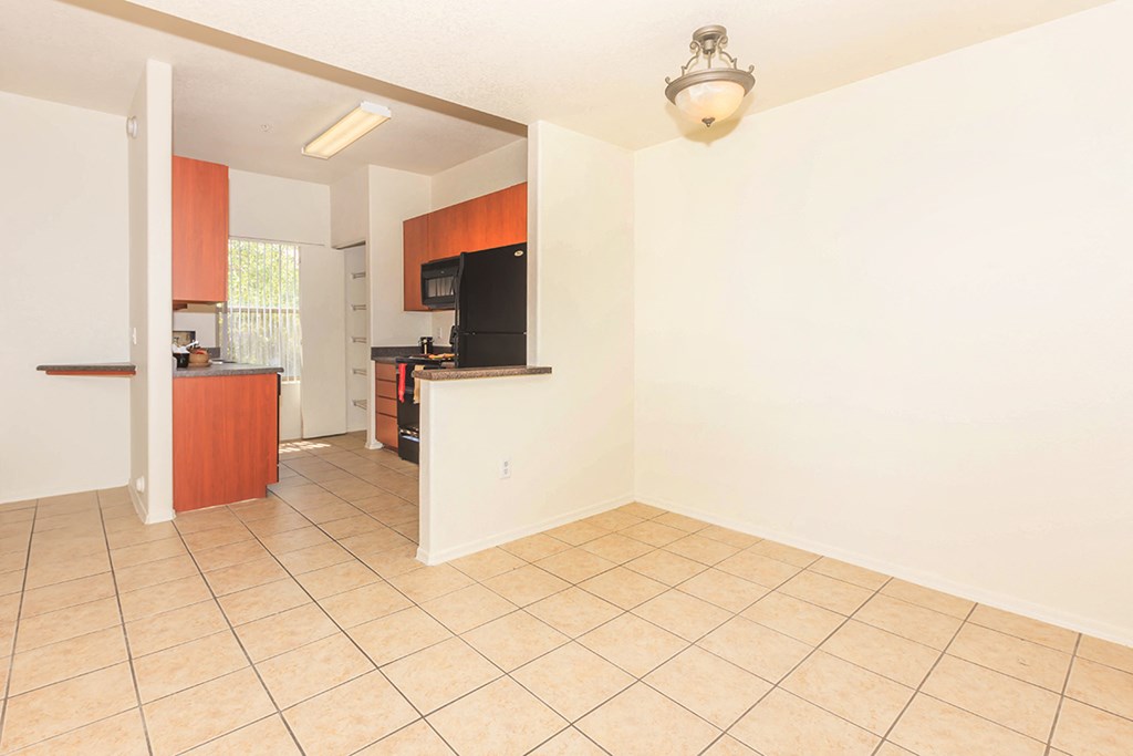 an empty kitchen and living room with a tile floor