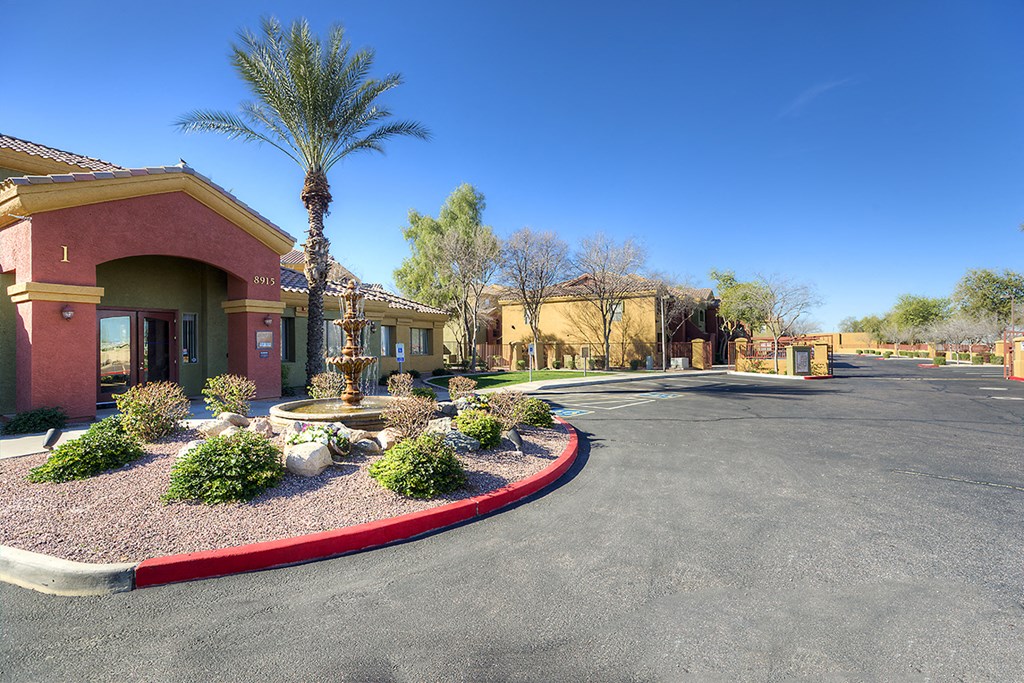 a roundabout in front of a building with palm trees