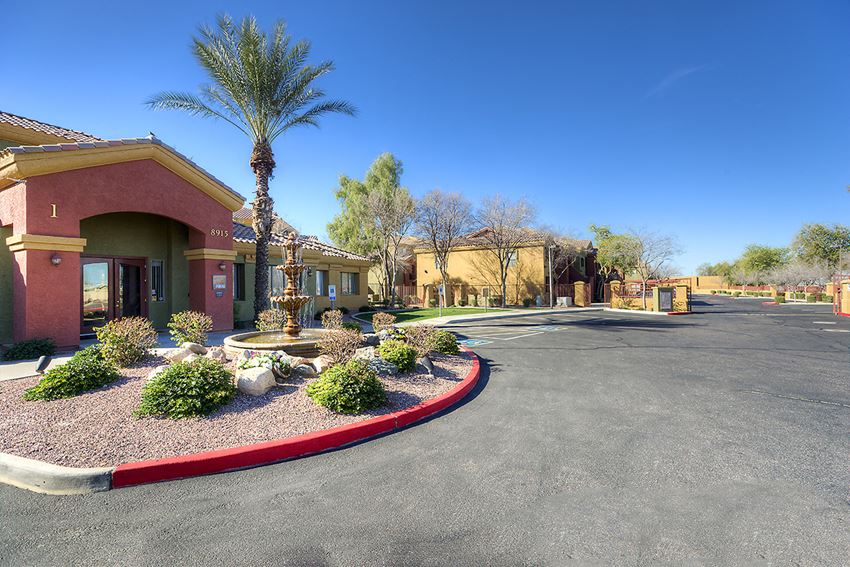 a roundabout in front of a building with palm trees