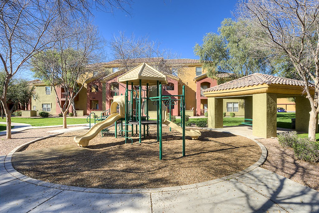 a playground with a slide in front of some apartments