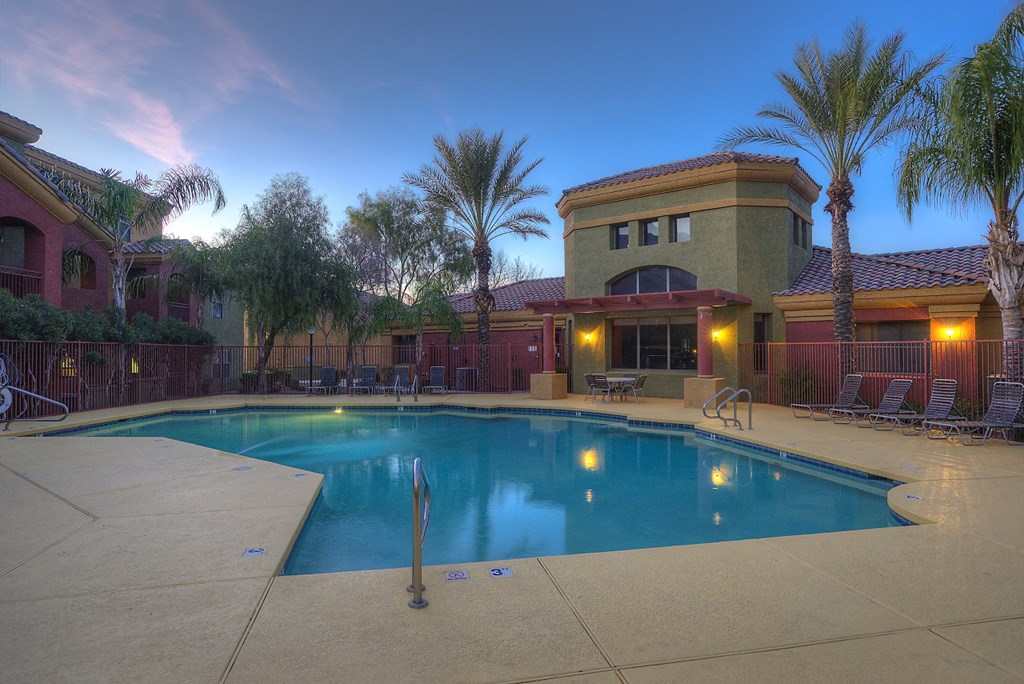 a swimming pool in front of a building at dusk