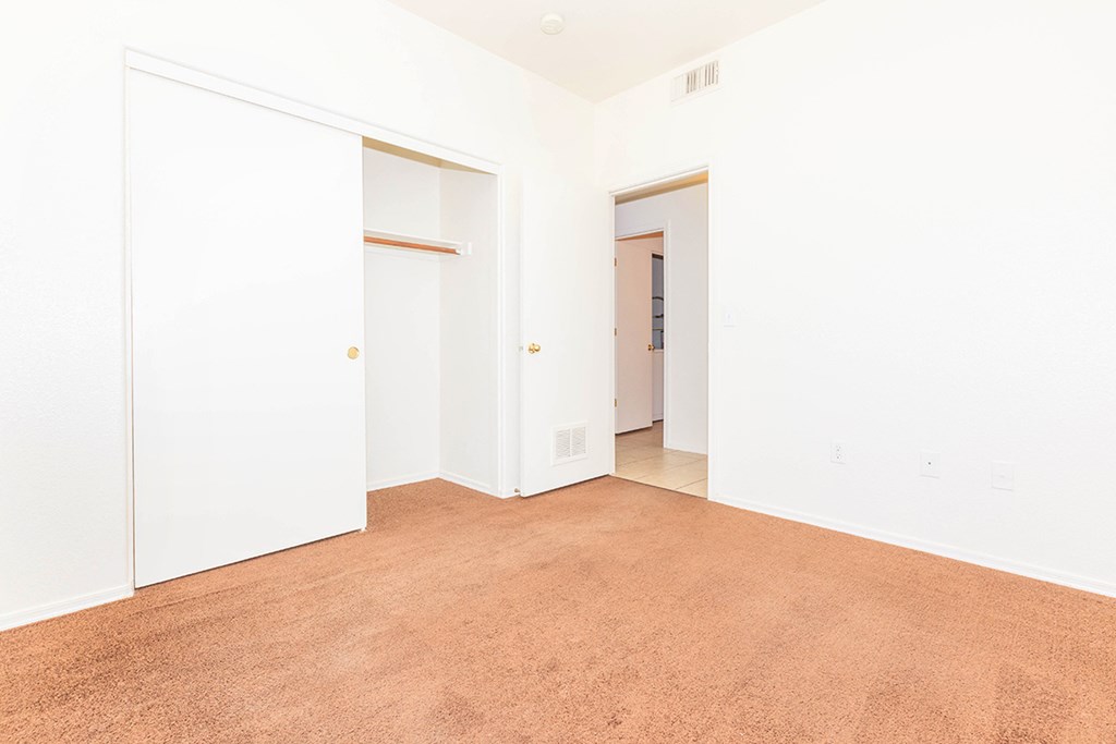 an empty room with white walls and a carpet