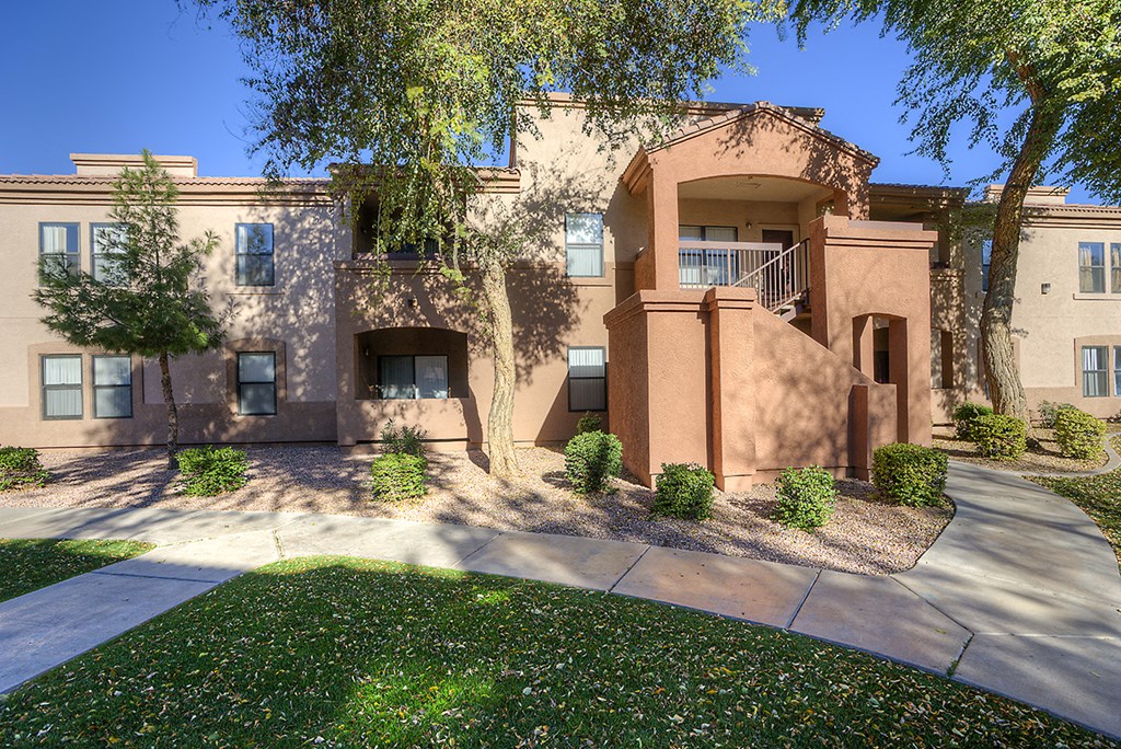 a view of the front of a building with trees and a sidewalk