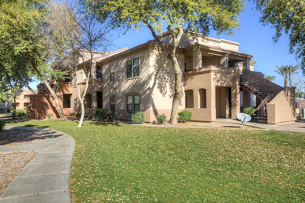 a house with a yard and trees in front of it