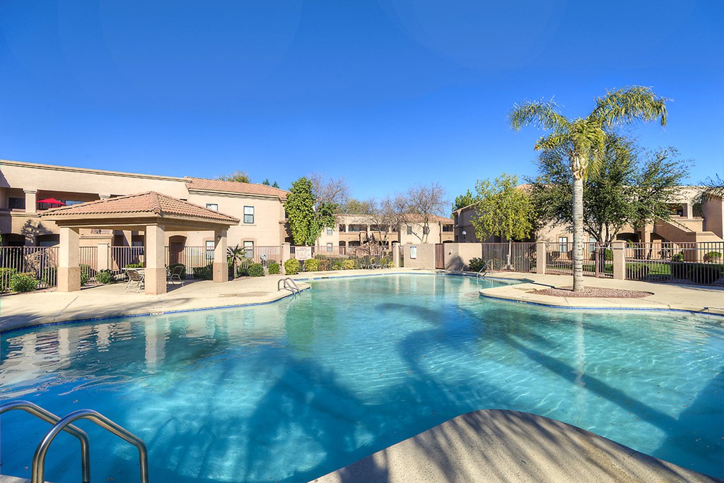 a large swimming pool with apartments in the background