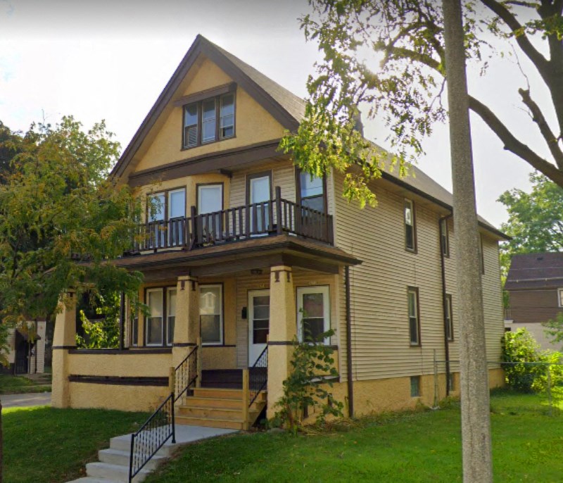 A two-story house with a balcony on the second floor.