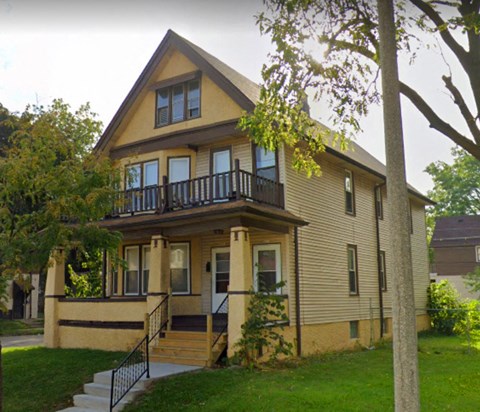 A two-story house with a balcony on the second floor.