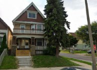 A house with a red roof and a porch.
