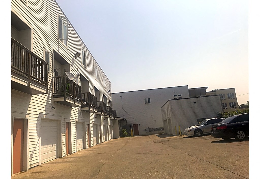 the side of a building with cars parked next to it