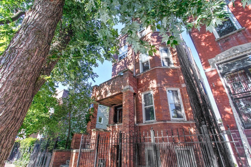 an old brick building with trees in front of it