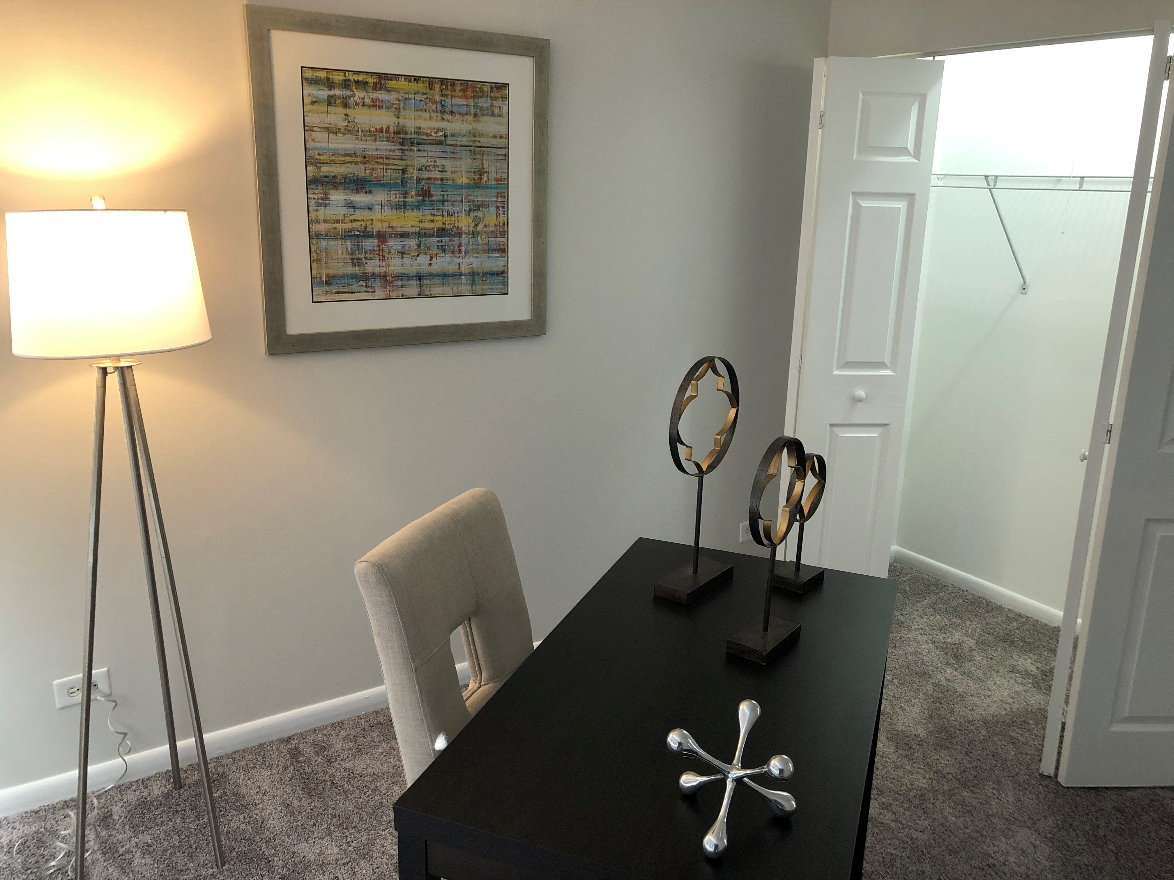 a home office with a desk and a lamp