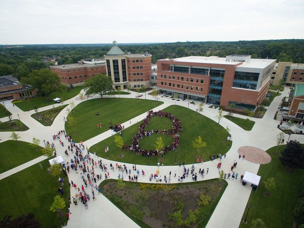 an aerial view of a crowd of people in a circle on the campus of a