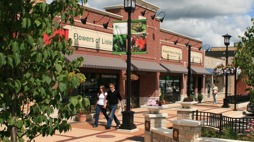 a couple walking past a flowers of life store on a city street