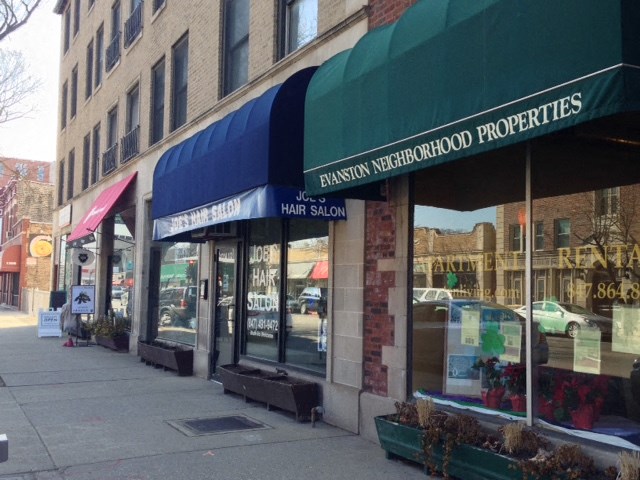 the front of a store with green and blue awning on a city street