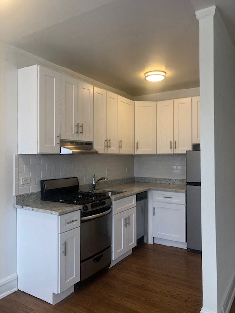 a kitchen with white cabinets and a stove and refrigerator