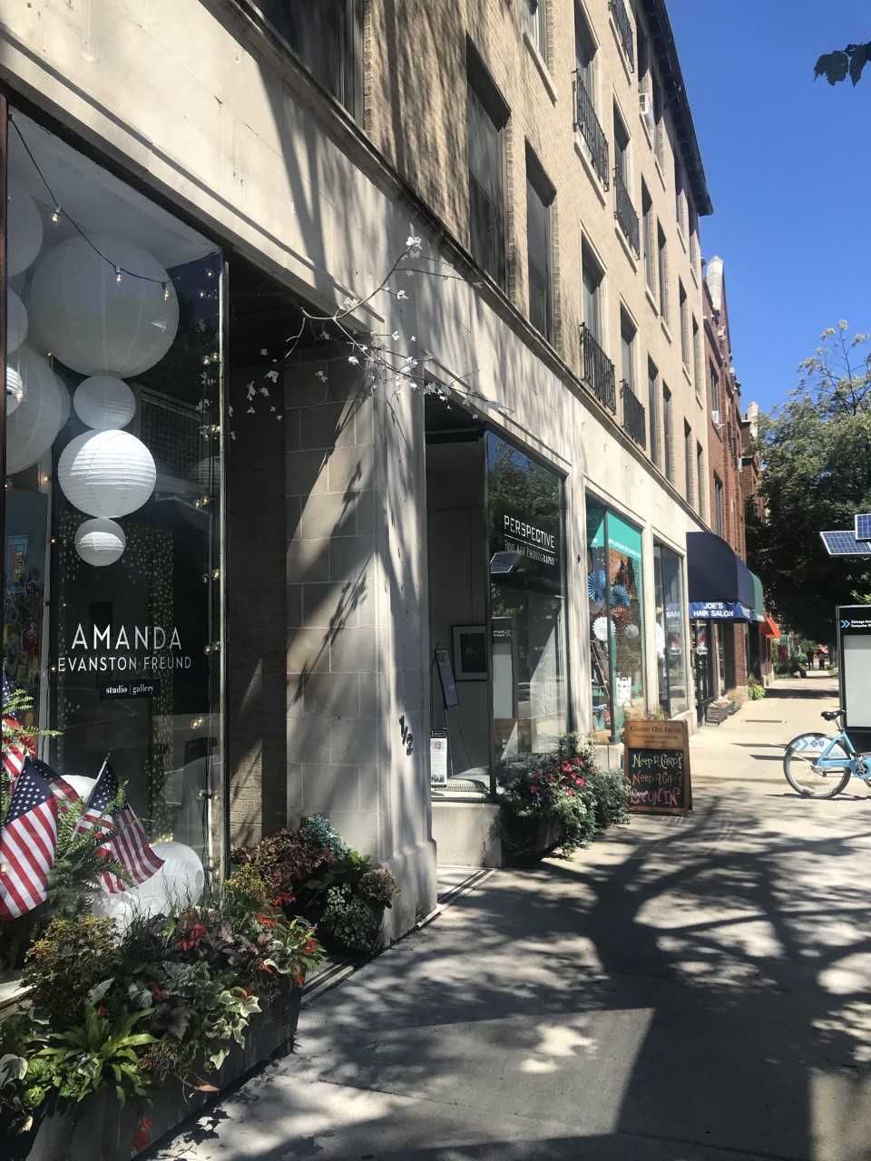 a street view of a building with flowers in front of it