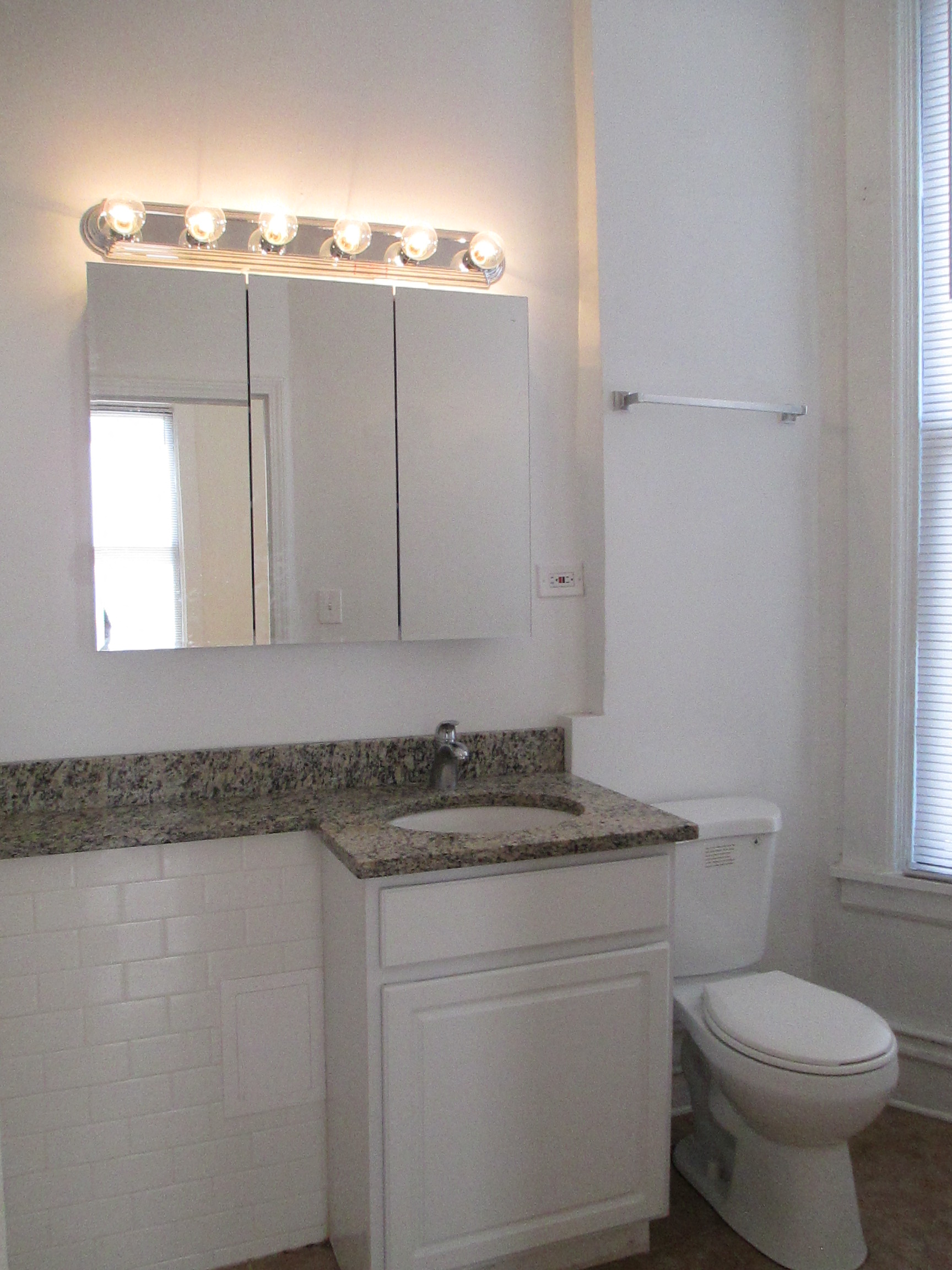 a bathroom with a toilet and a sink and a mirror