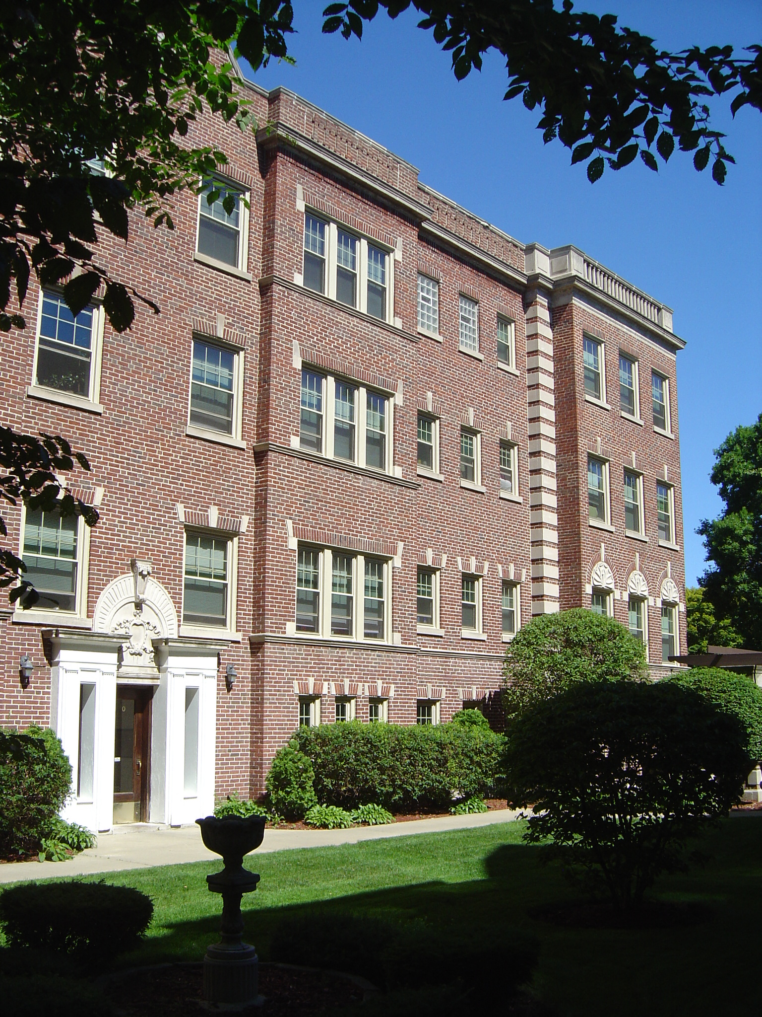a large brick building with a lawn in front of it