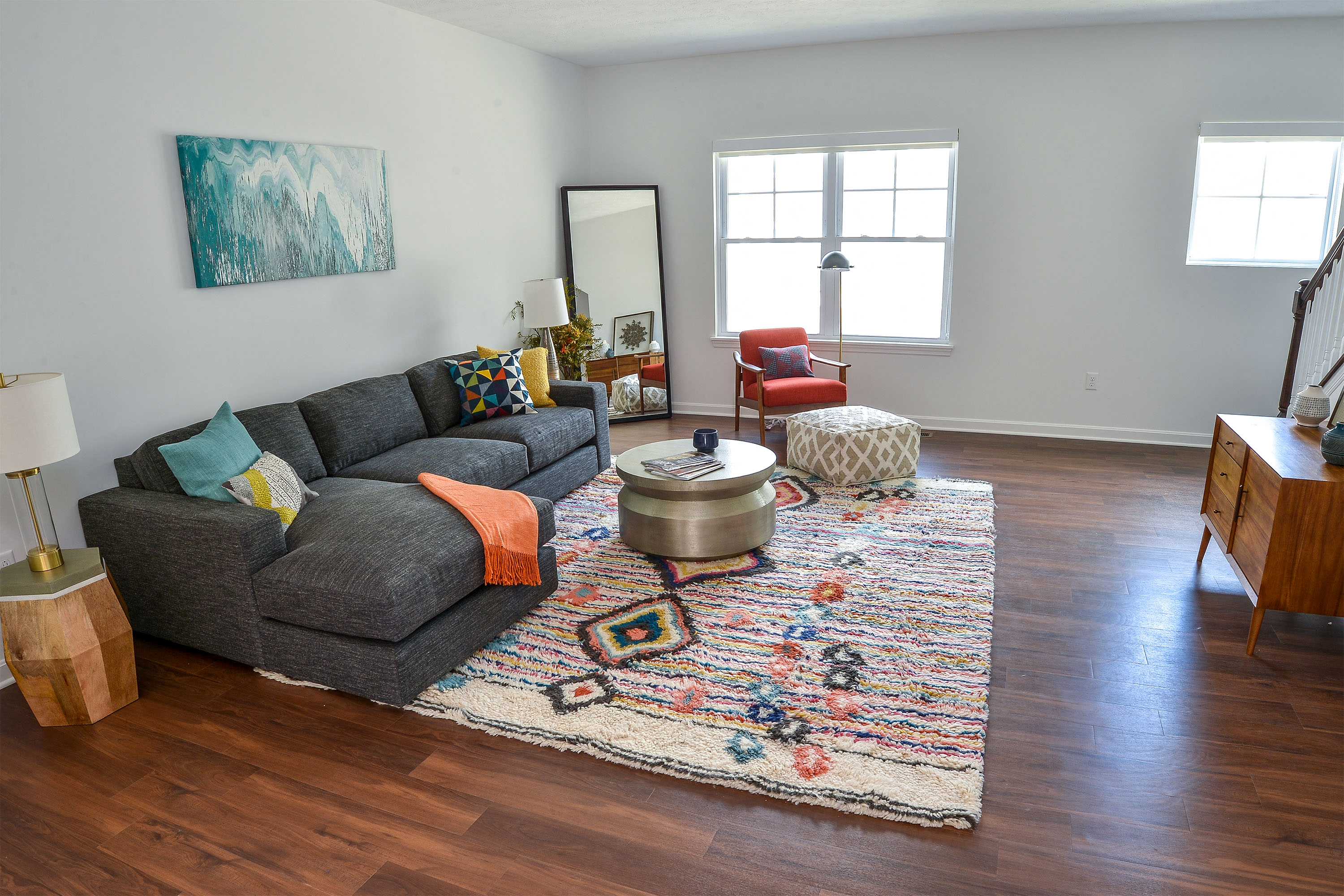 a living room with a gray couch and a rug