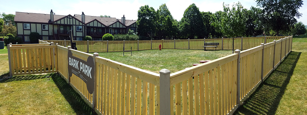 a wooden fence around a yard with a dog park