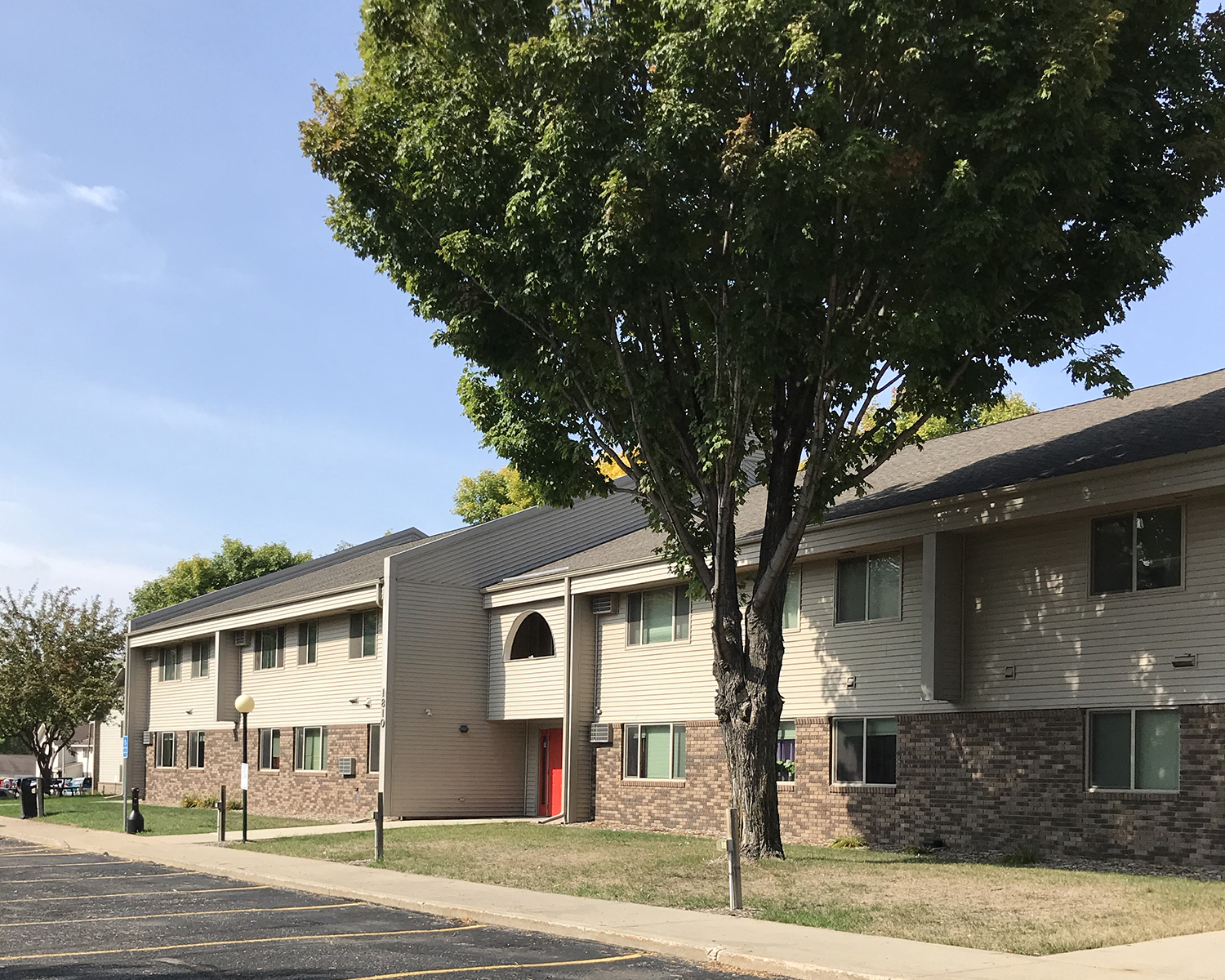 an apartment building with a tree in front of it