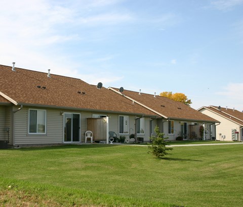 A row of houses with brown roofs and grey walls.
