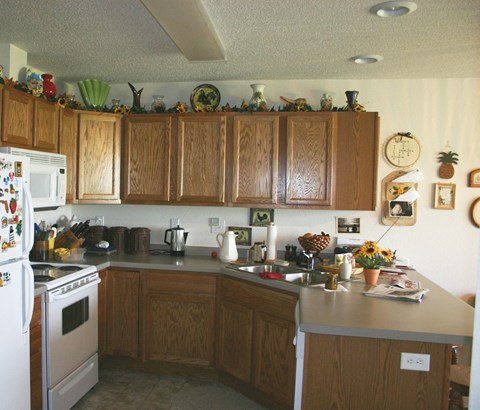 A kitchen with wooden cabinets and a white fridge.