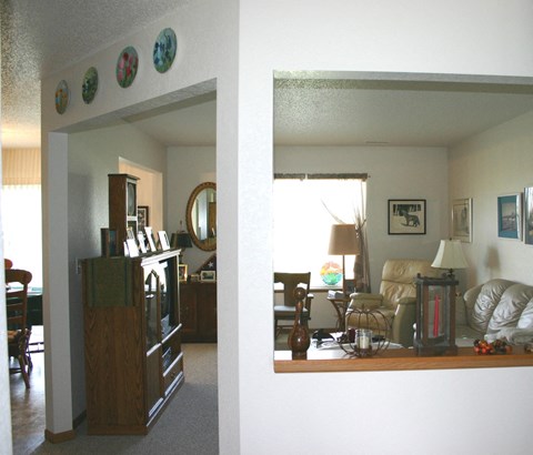 A living room with a couch, chair, lamp, and a picture on the wall.