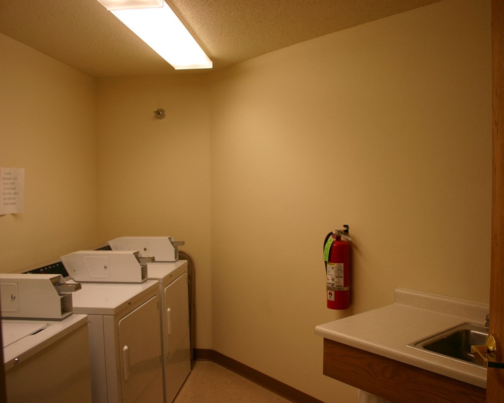 a laundry room with a washer and dryer and a fire extinguisher