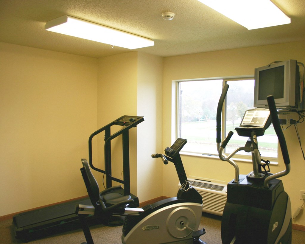 a workout room with a treadmill and a tv