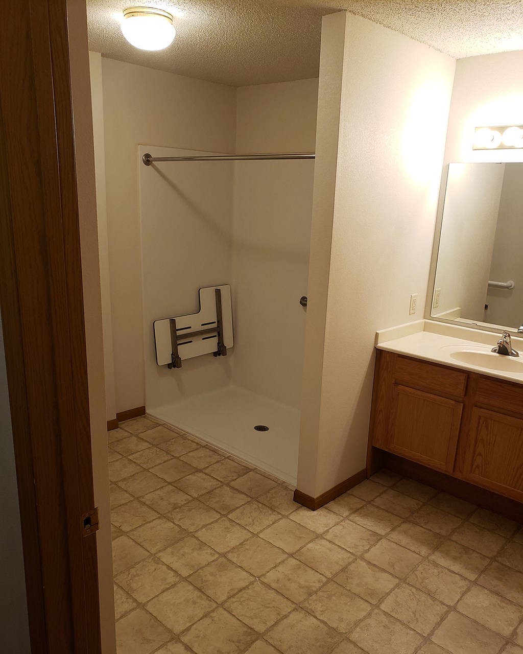 a bathroom with a shower and a sink and a mirror