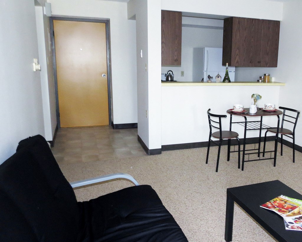 a living room with a couch and a table and a kitchen