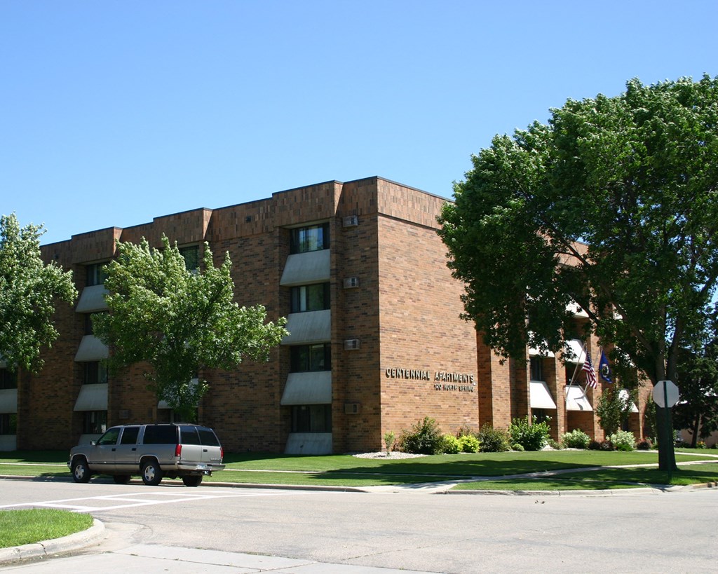 a large brick building with a van parked in front of it