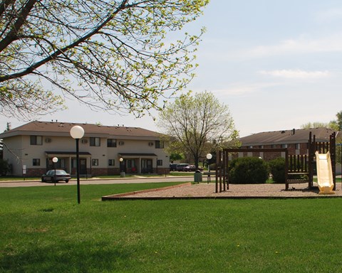 a park with a playground and a building in the background