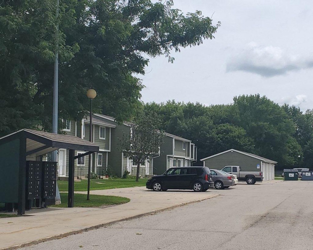 a parking lot with cars parked in front of houses